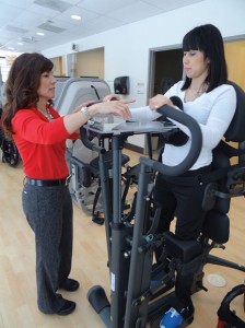 The EasyStand Glider has moveable handles that generate reciprocal foot pedal movement. Good Shepherd’s Optimal Fitness Center uses the glider to increase the client’s range of motion and strength. Pictured: Cynthia Bauer, PT, DPT, OCS, and Optimal Fitness client Ruth Aragon.